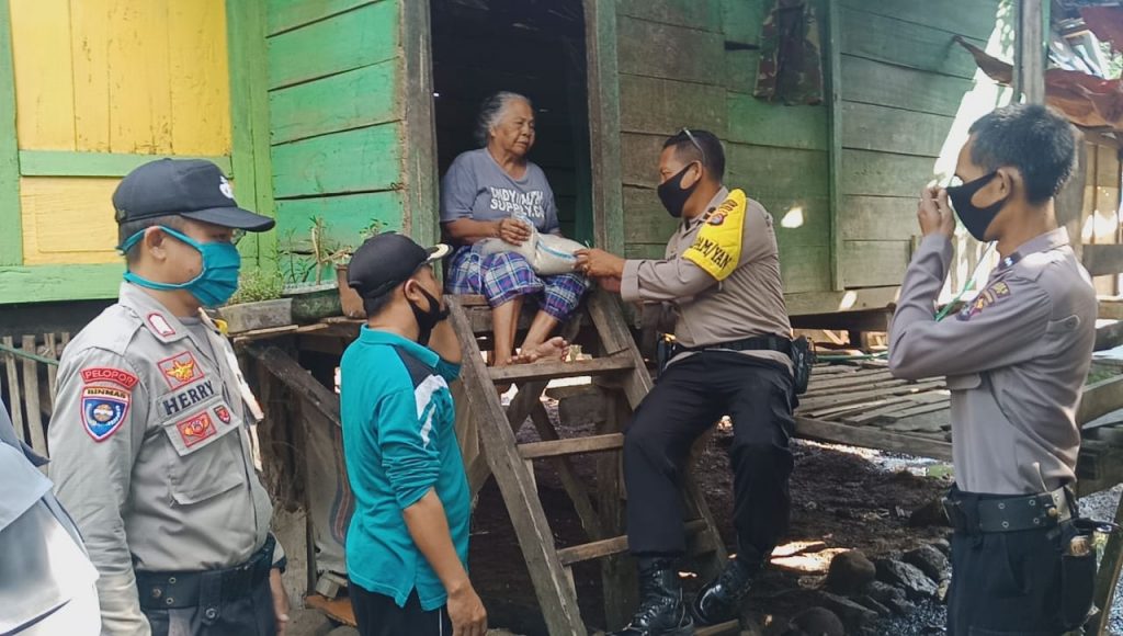 Kapolsek Woja Bagikan Bantuan Beras dan Imbau Warga Tetap Ikuti Anjuran Pemerintah Cegah Covid-19.
