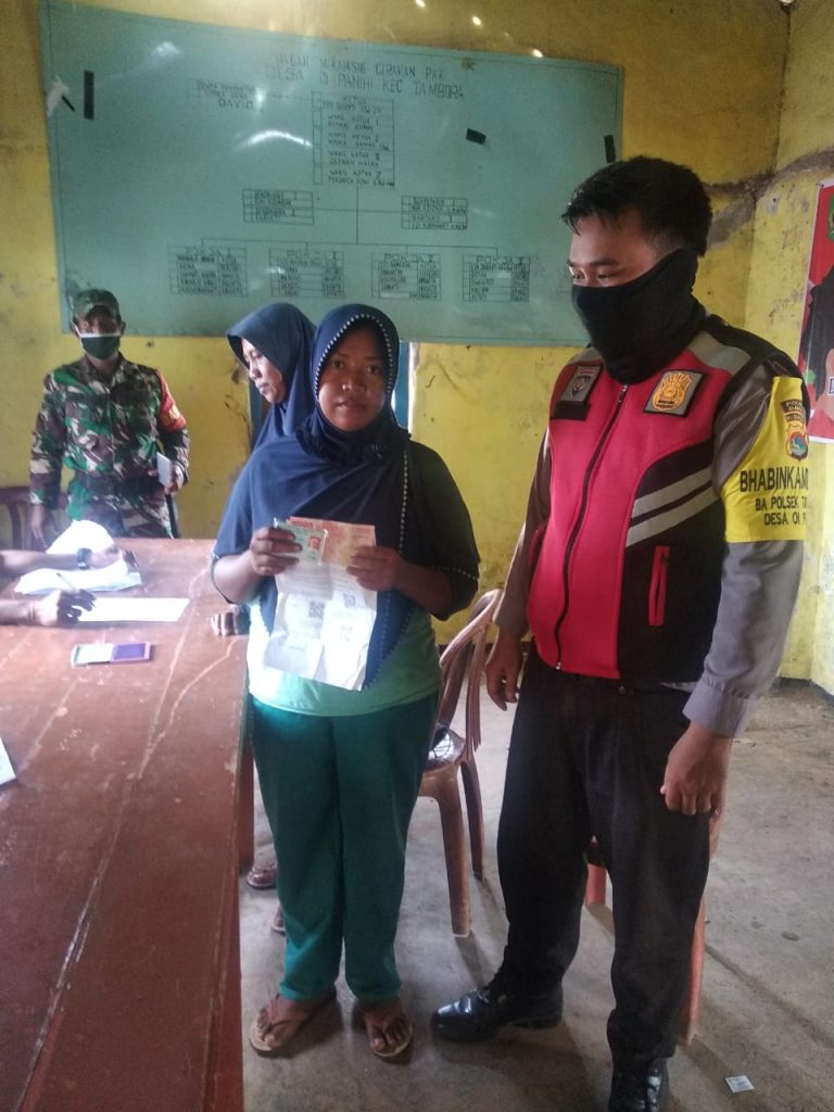 Bhabinkamtibmas Polsek Tambora Bima Amankan Penyaluran BST. Warga Diimbau Tetap Ikuti Protokol Kesehatan.