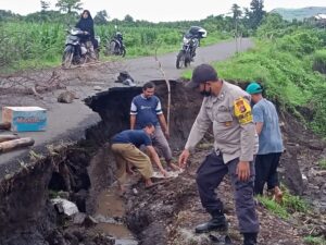 Bhabinkamtibmas Desa Teka sire Bantu perbaikan jalan Rusak Akibat Air Meluap