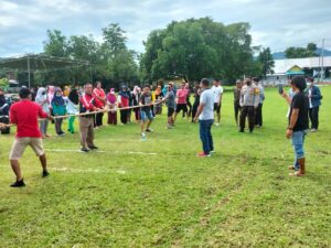 Ikuti Kegiatan Tarik Tambang, Bhabinkamtibmas Imbau Warga Tetap Patuhi Protokol Kesehatan